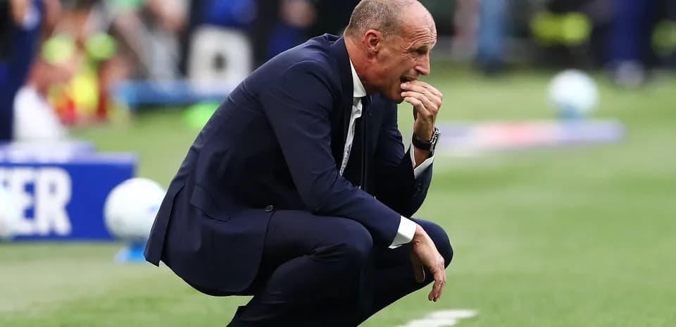 Entrenador agachado durante un partido de fútbol