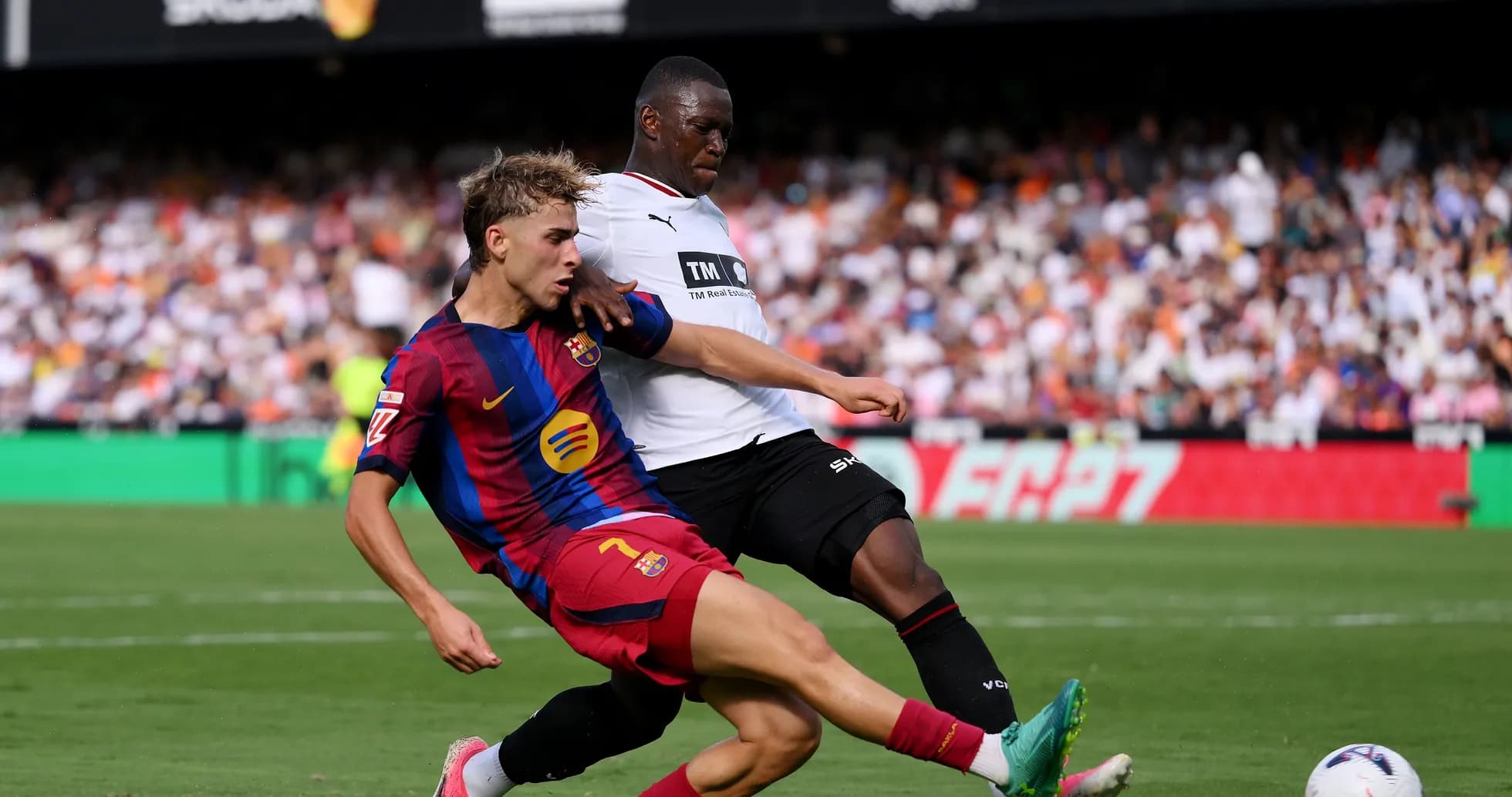 Jugador de Barcelona deslizándose por el balón en partido