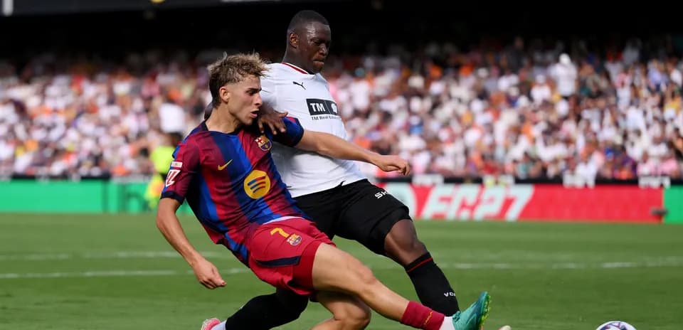 Jugador de Barcelona deslizándose por el balón en partido