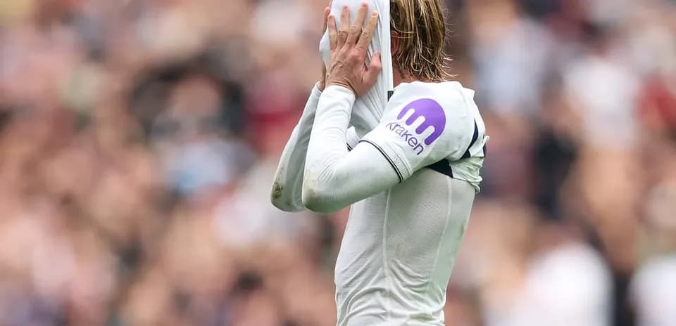 Jugador cubriendo su cara con la camiseta durante partido
