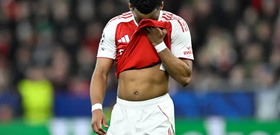 Jugador de fútbol con camiseta roja cubriendo su rostro