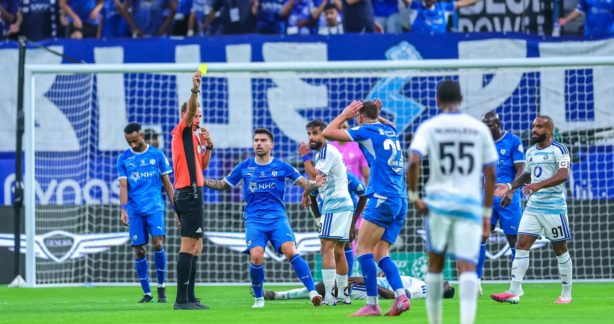 Árbitro muestra tarjeta amarilla en partido de fútbol