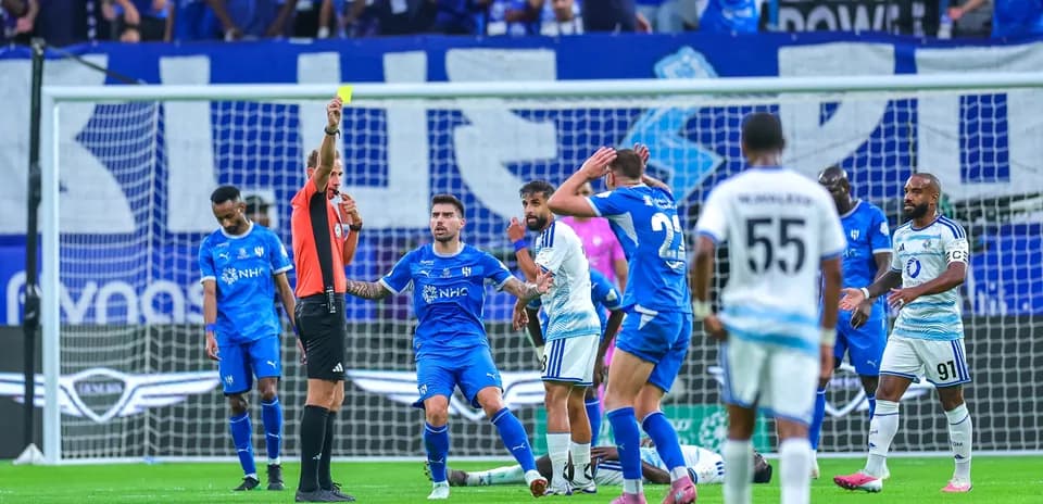 Árbitro muestra tarjeta amarilla en partido de fútbol
