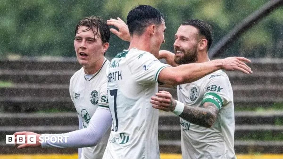 Jugadores de Hibernian celebrando un gol bajo la lluvia