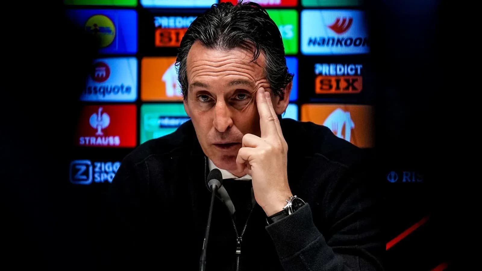 Entrenador en rueda de prensa señalando su frente