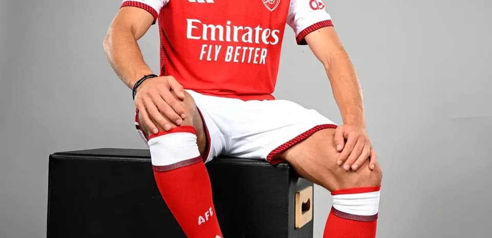 Jugador de Arsenal posando con balón de fútbol