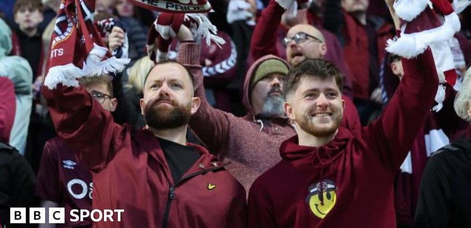 Aficionados sosteniendo bufandas en un estadio