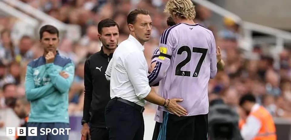 Entrenador hablando con el portero durante el partido