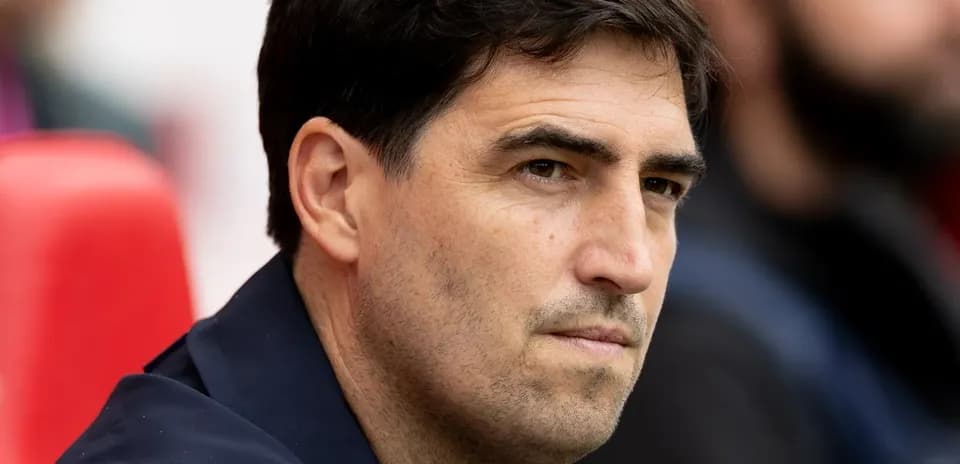 Entrenador observando desde el banquillo durante partido