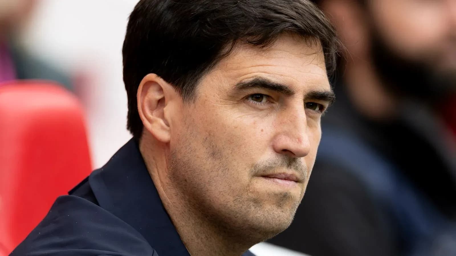 Entrenador observando desde el banquillo durante partido