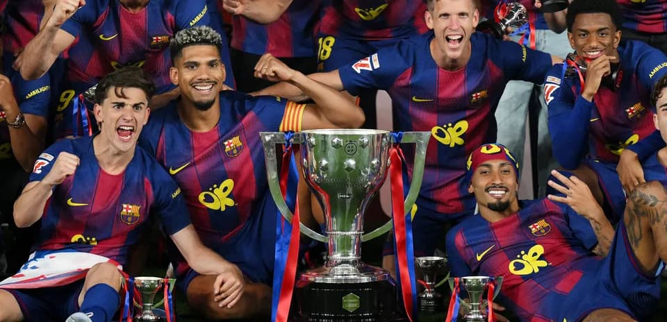 Jugadores del FC Barcelona celebrando con trofeos