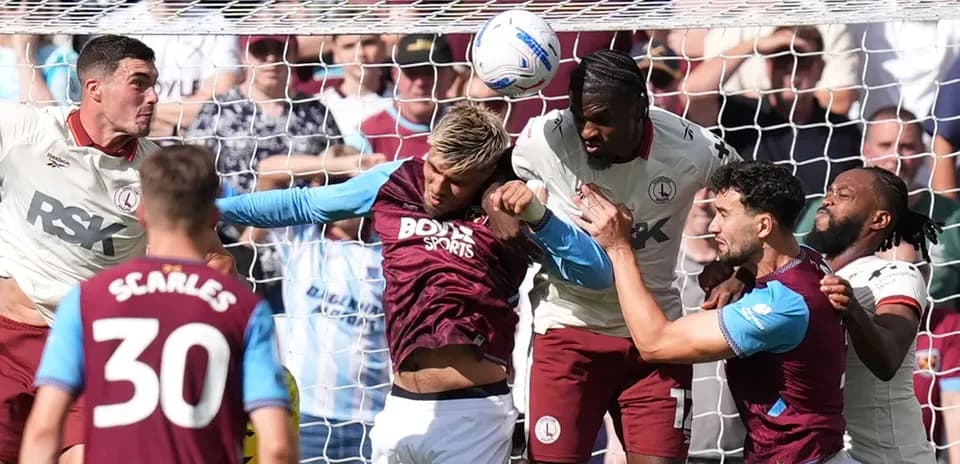 Jugadores disputando un balón en el área penal