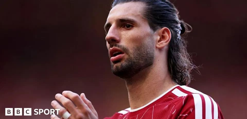 Jugador de fútbol con camiseta roja en el campo