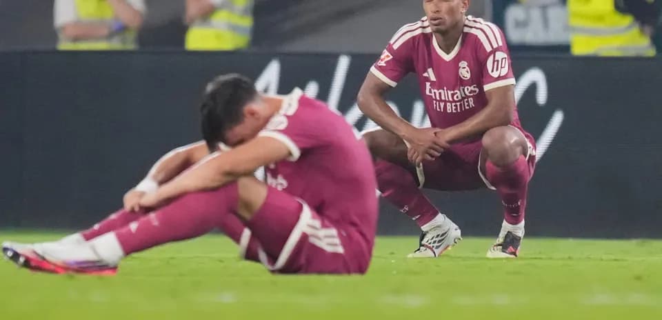 Jugadores de Real Madrid sentados en el campo tras el partido