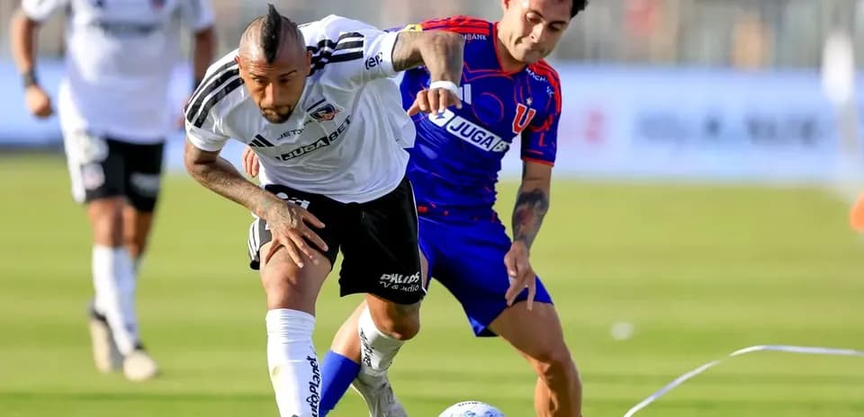 Arturo Vidal y jugador de Universidad de Chile luchando por el balón