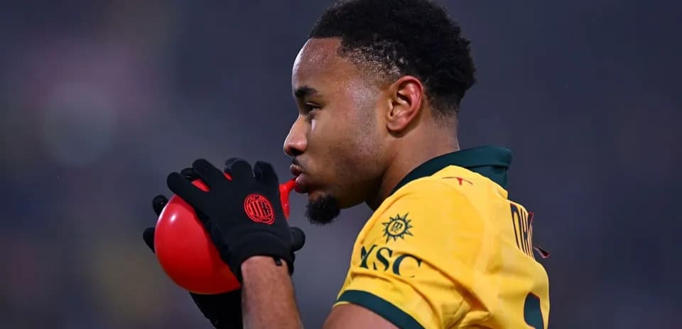 Jugador sosteniendo un balón rojo durante el partido