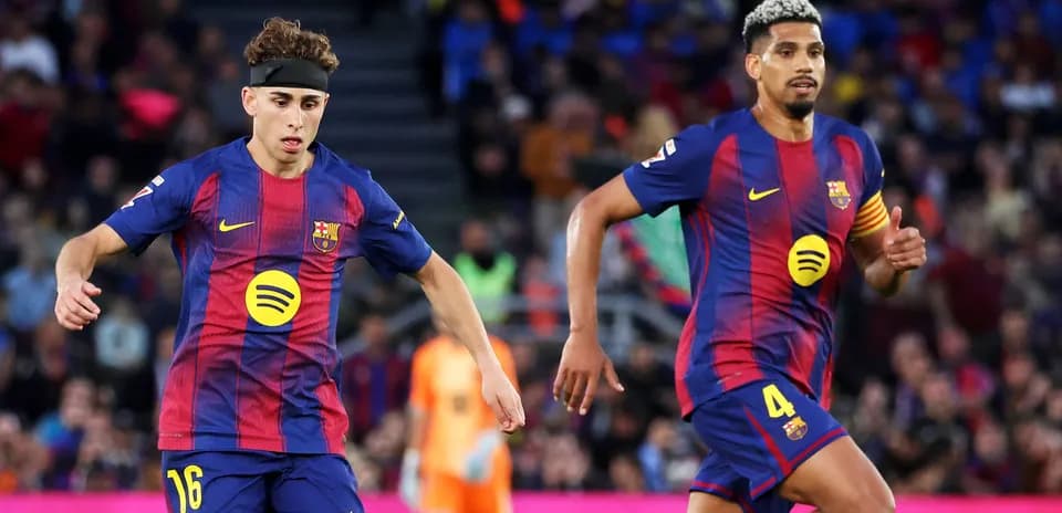 Dos jugadores del FC Barcelona corriendo en el campo