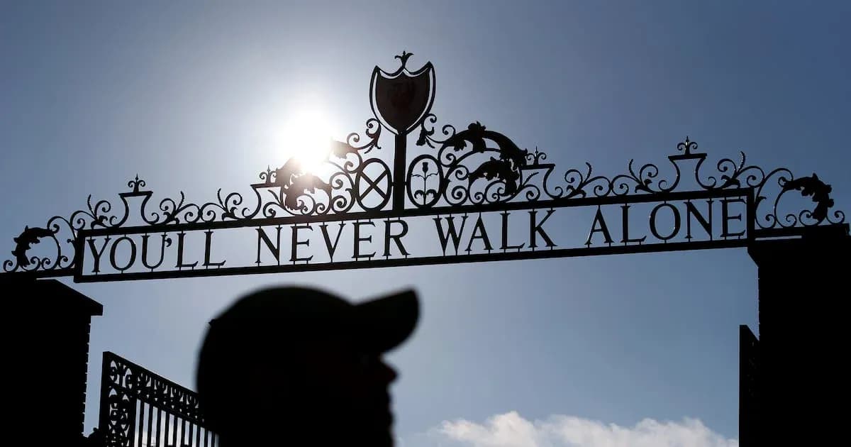 Puerta con lema 'YOU'LL NEVER WALK ALONE' iluminada por sol
