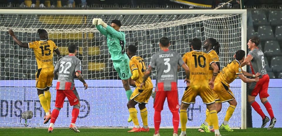 Portero saltando para atrapar el balón en partido