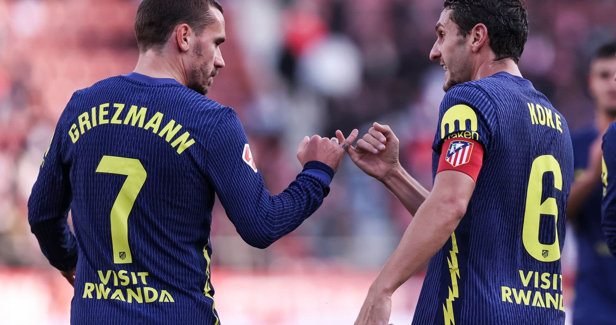 Griezmann y Koke celebrando en el campo