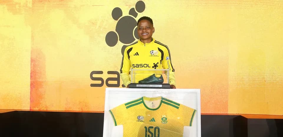 Jugador sosteniendo bota y camiseta en evento