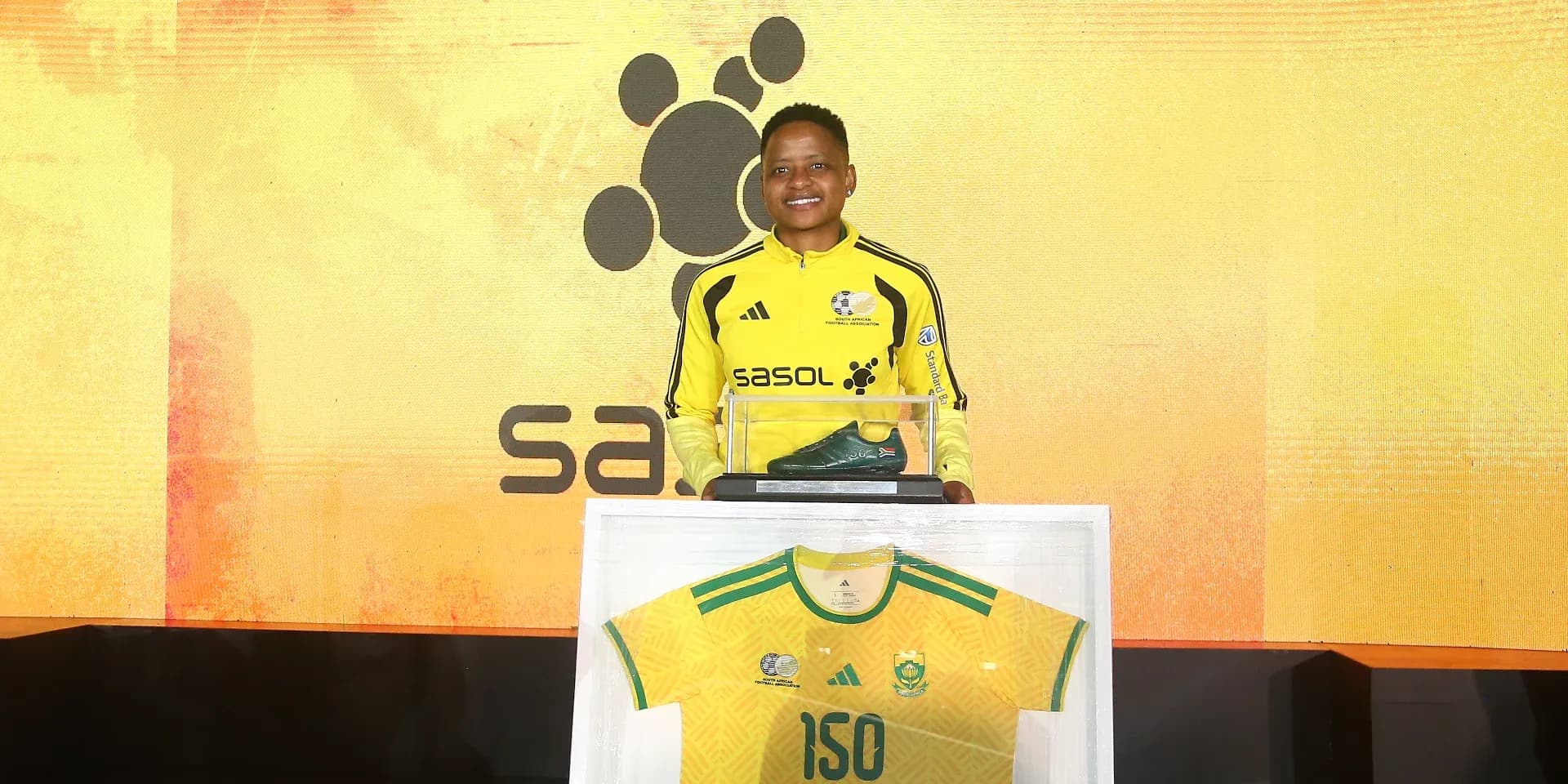 Jugador sosteniendo bota y camiseta en evento