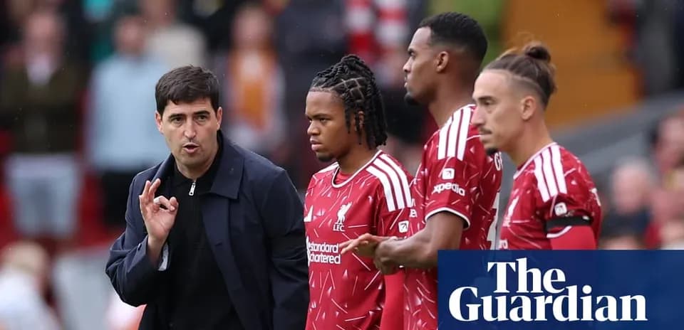 Entrenador hablando con jugadores de Liverpool en el campo