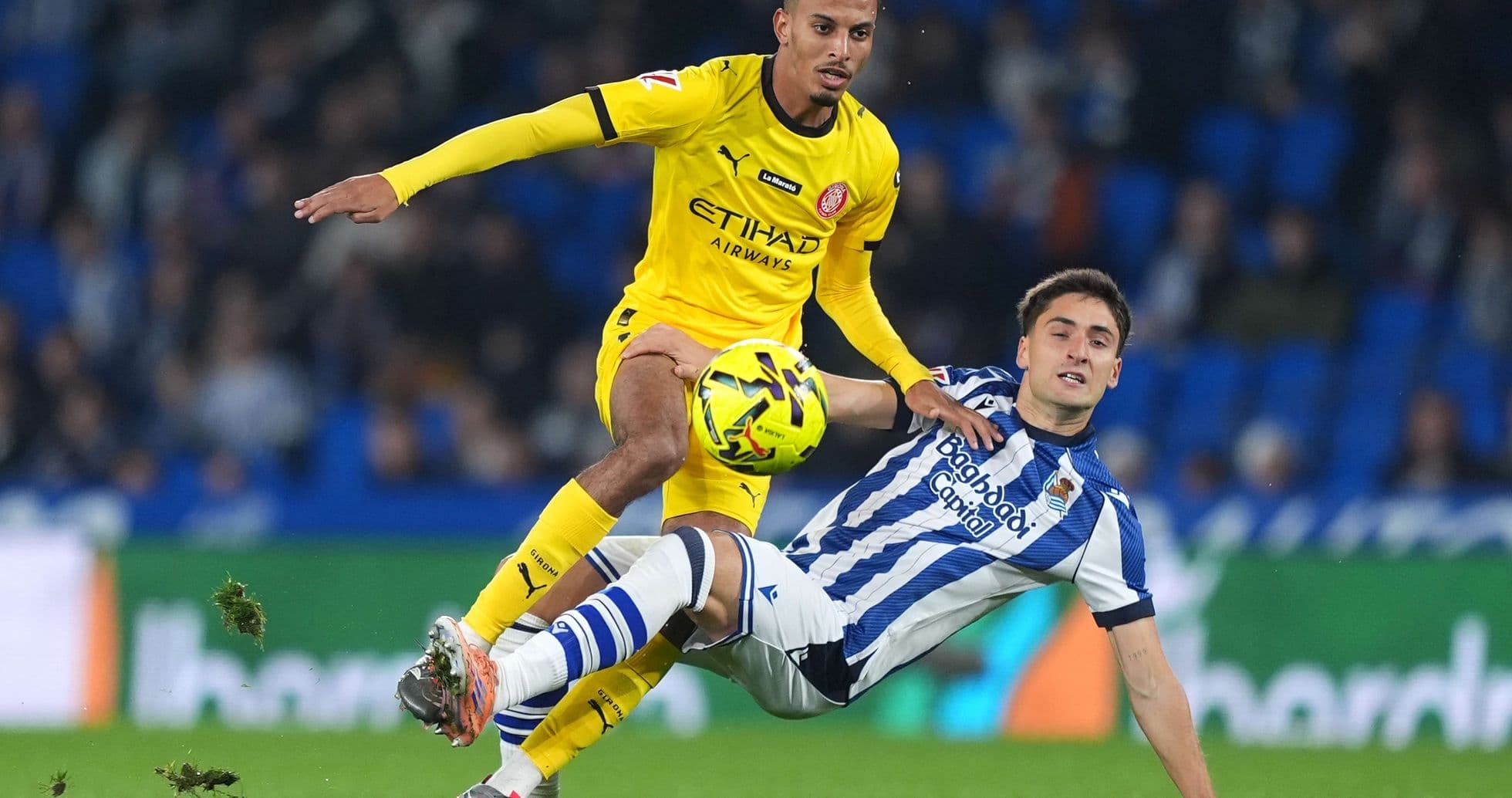 Jugador de Girona desafiando a jugador de Real Sociedad