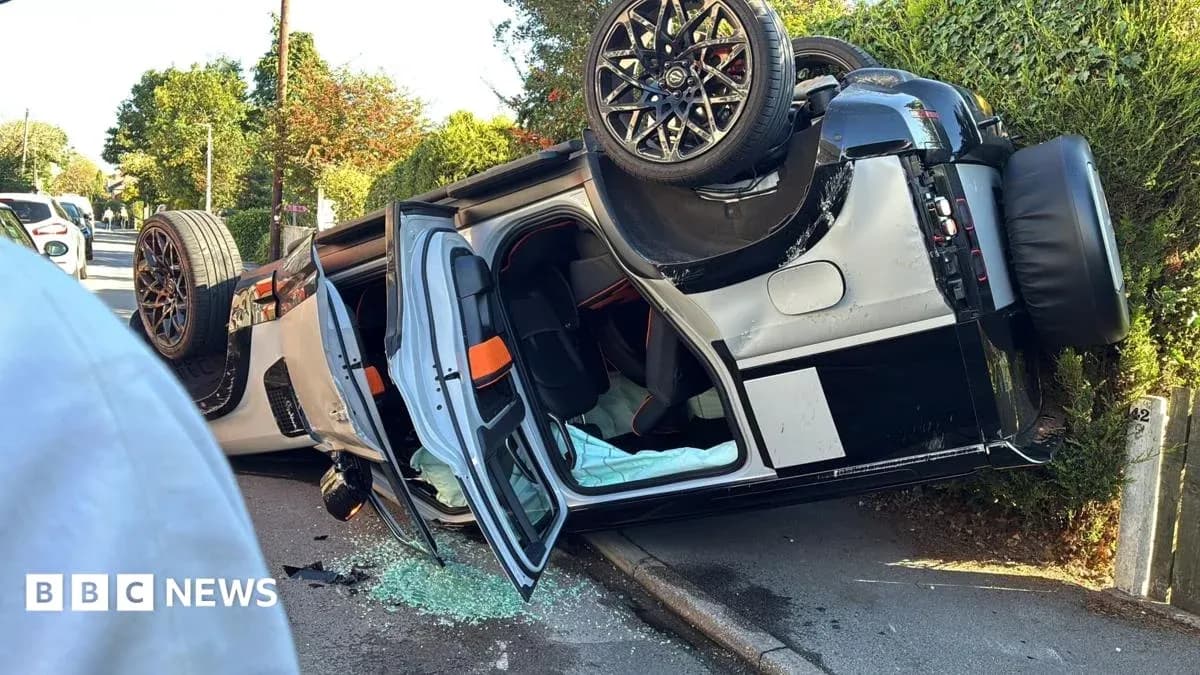 Coche volcado en la acera con vidrios rotos