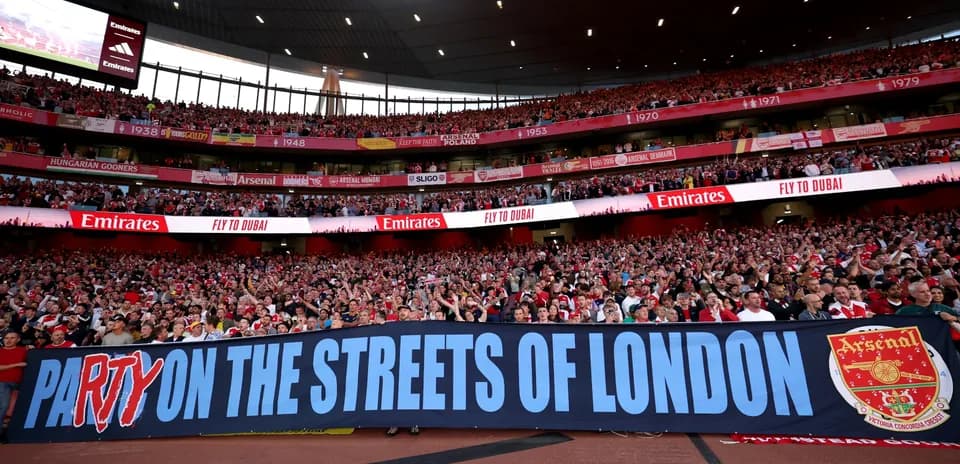 Aficionados de Arsenal con pancarta en el estadio