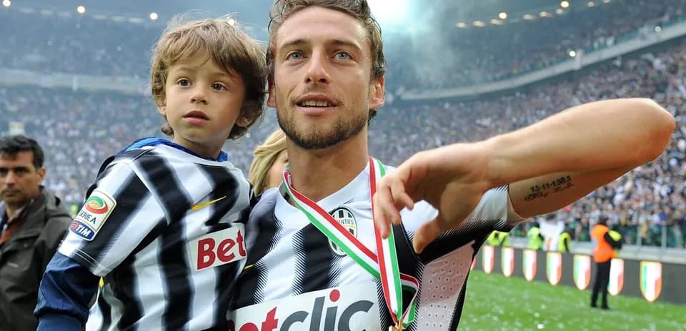 Jugador con medalla sosteniendo a un niño en el campo