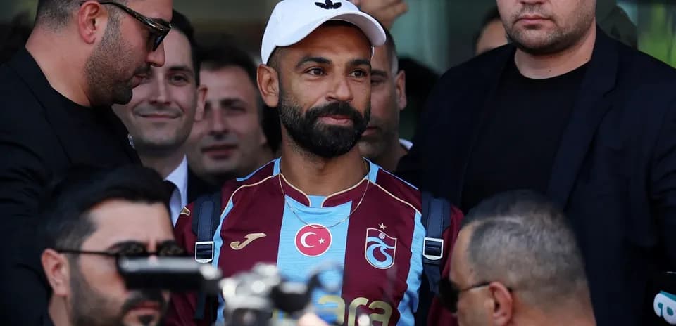 Jugador de Trabzonspor rodeado de seguridad y periodistas