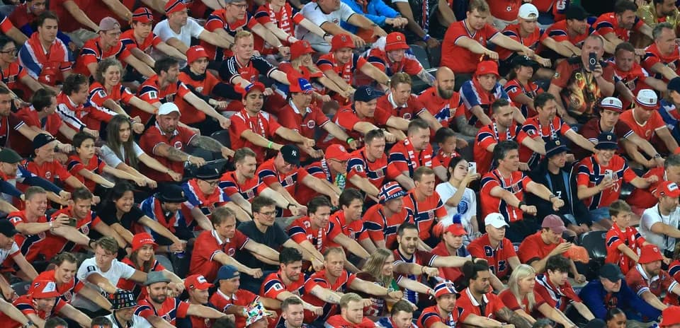 Aficionados en camiseta roja apoyando a su equipo