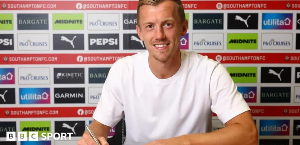 Jugador firmando contrato en mesa de prensa