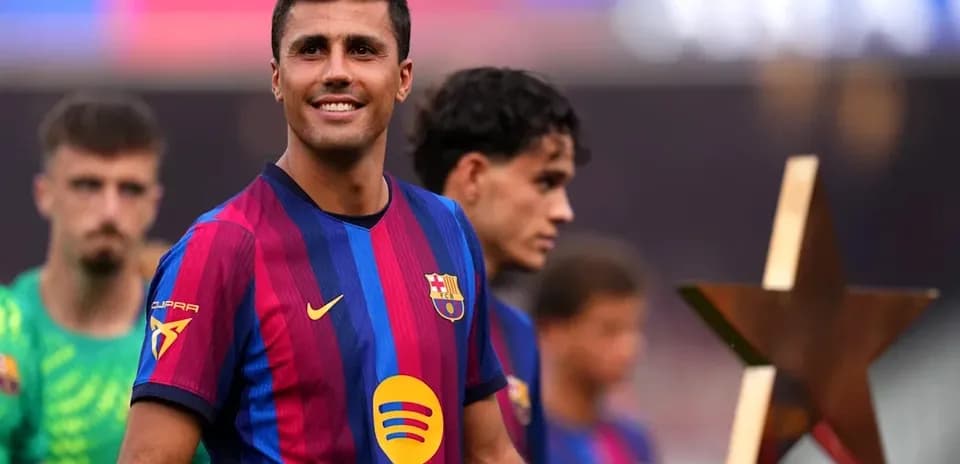 Jugador de FC Barcelona sonriendo con compañeros detrás