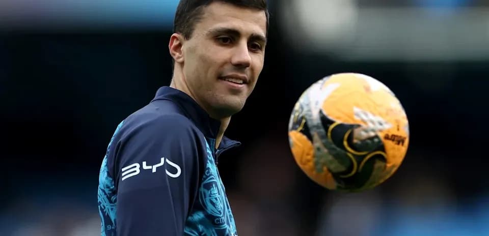 Jugador sosteniendo un balón de fútbol en el campo