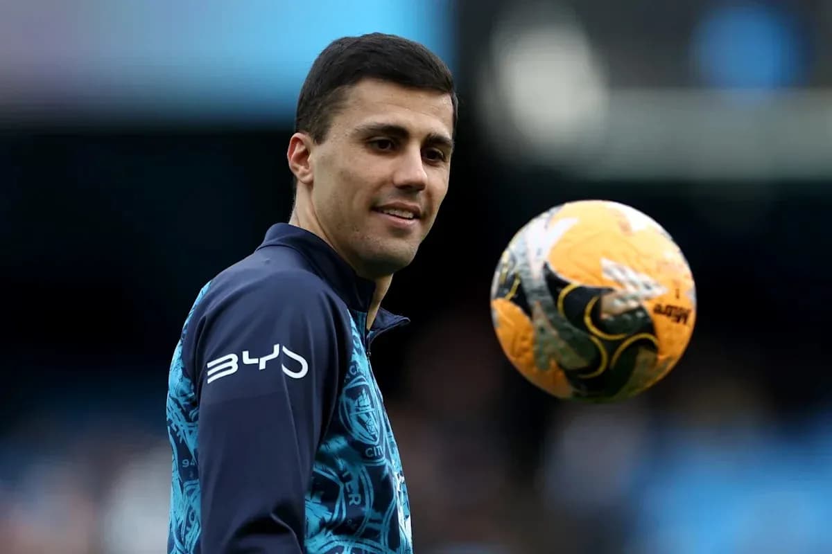 Jugador sosteniendo un balón de fútbol en el campo
