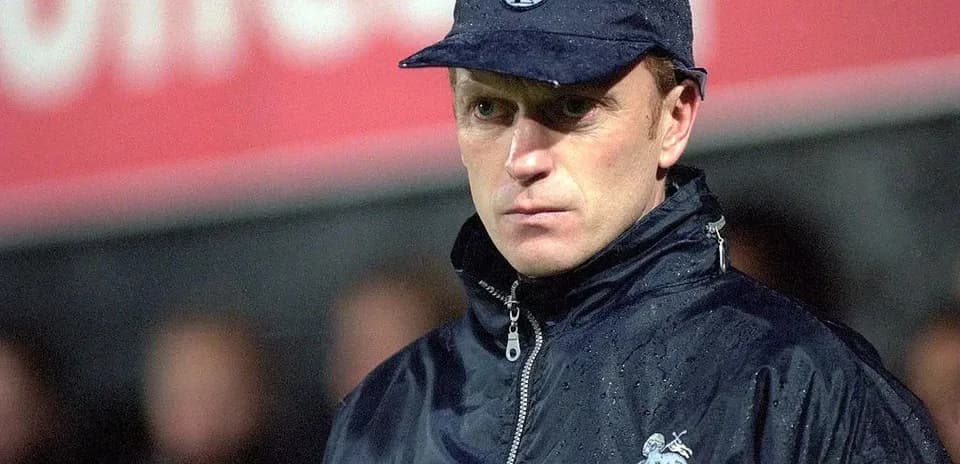 Entrenador de Preston North con chaqueta y gorra