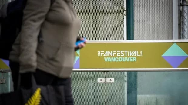 Persona caminando junto al cartel del Fan Festival Vancouver
