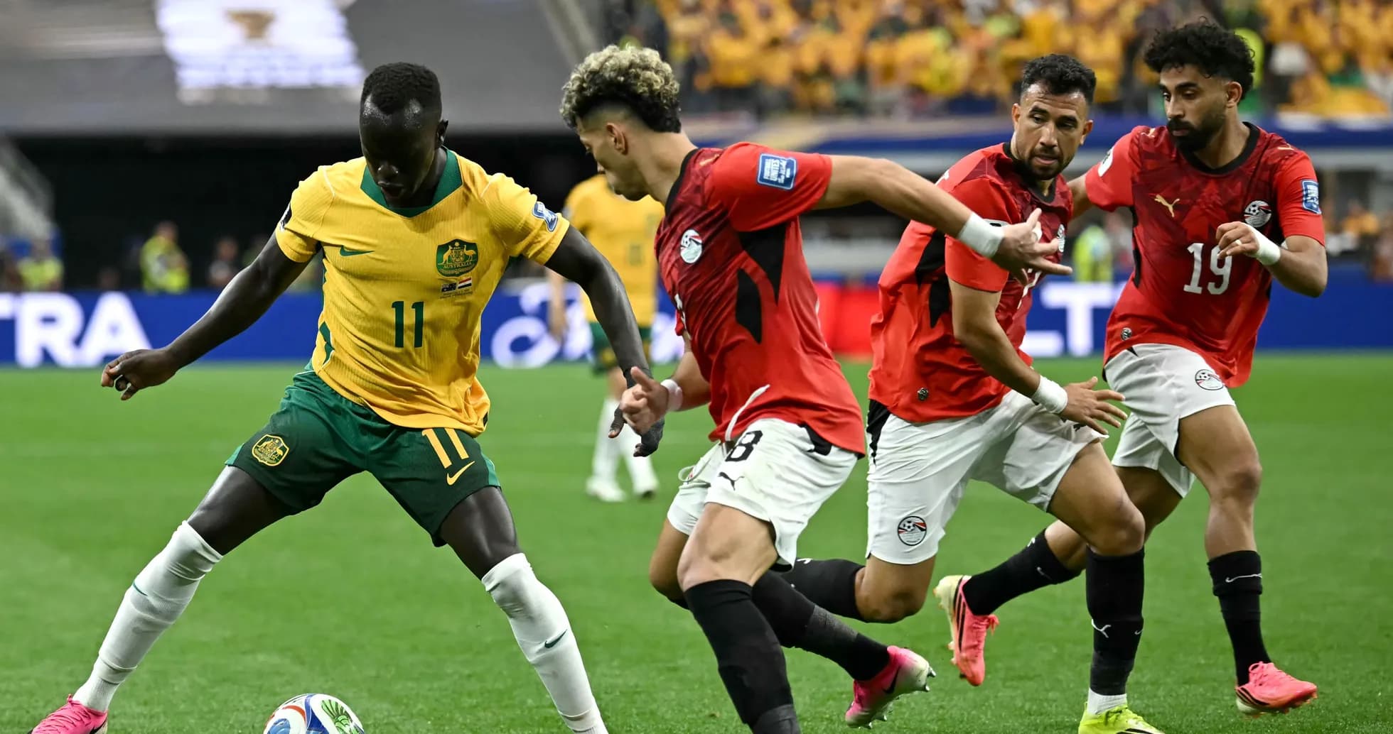 Jugador de Australia driblando ante defensores egipcios