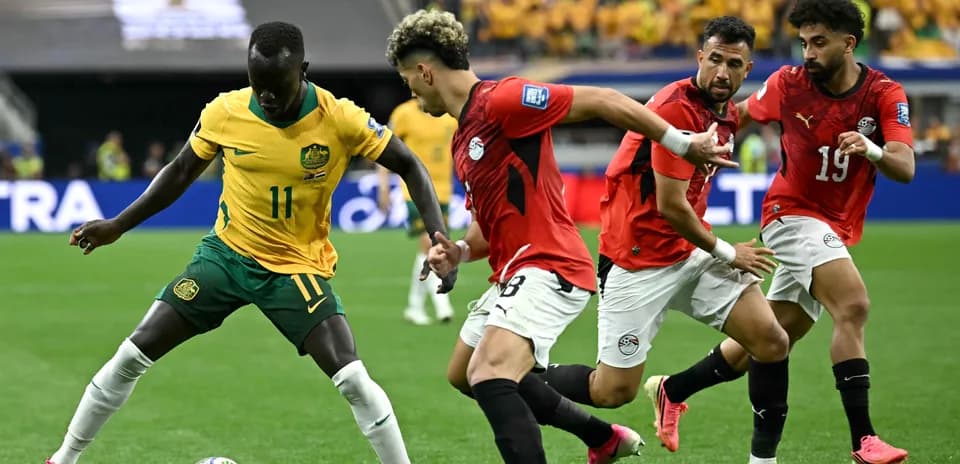 Jugador de Australia driblando ante defensores egipcios