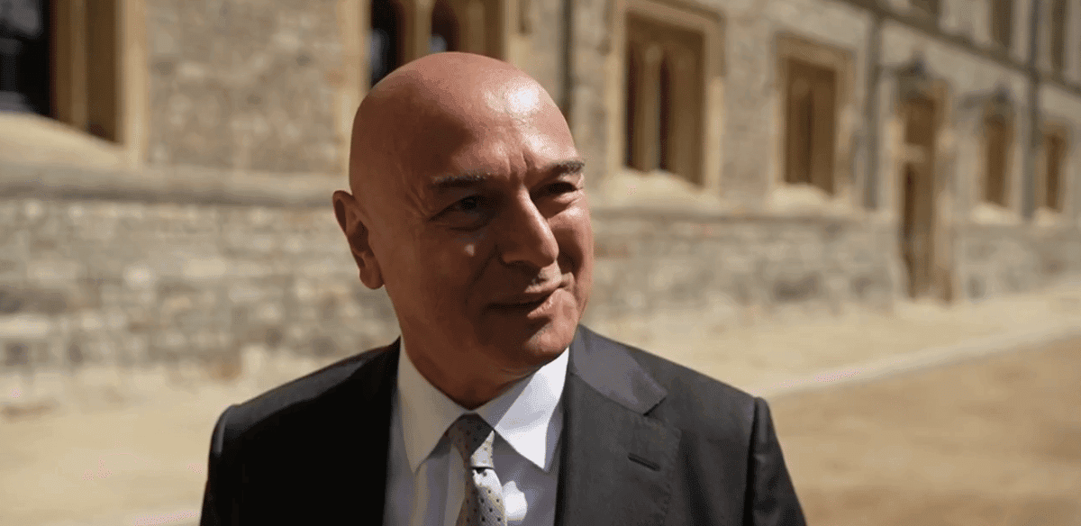 Hombre con traje sonriendo en exterior histórico