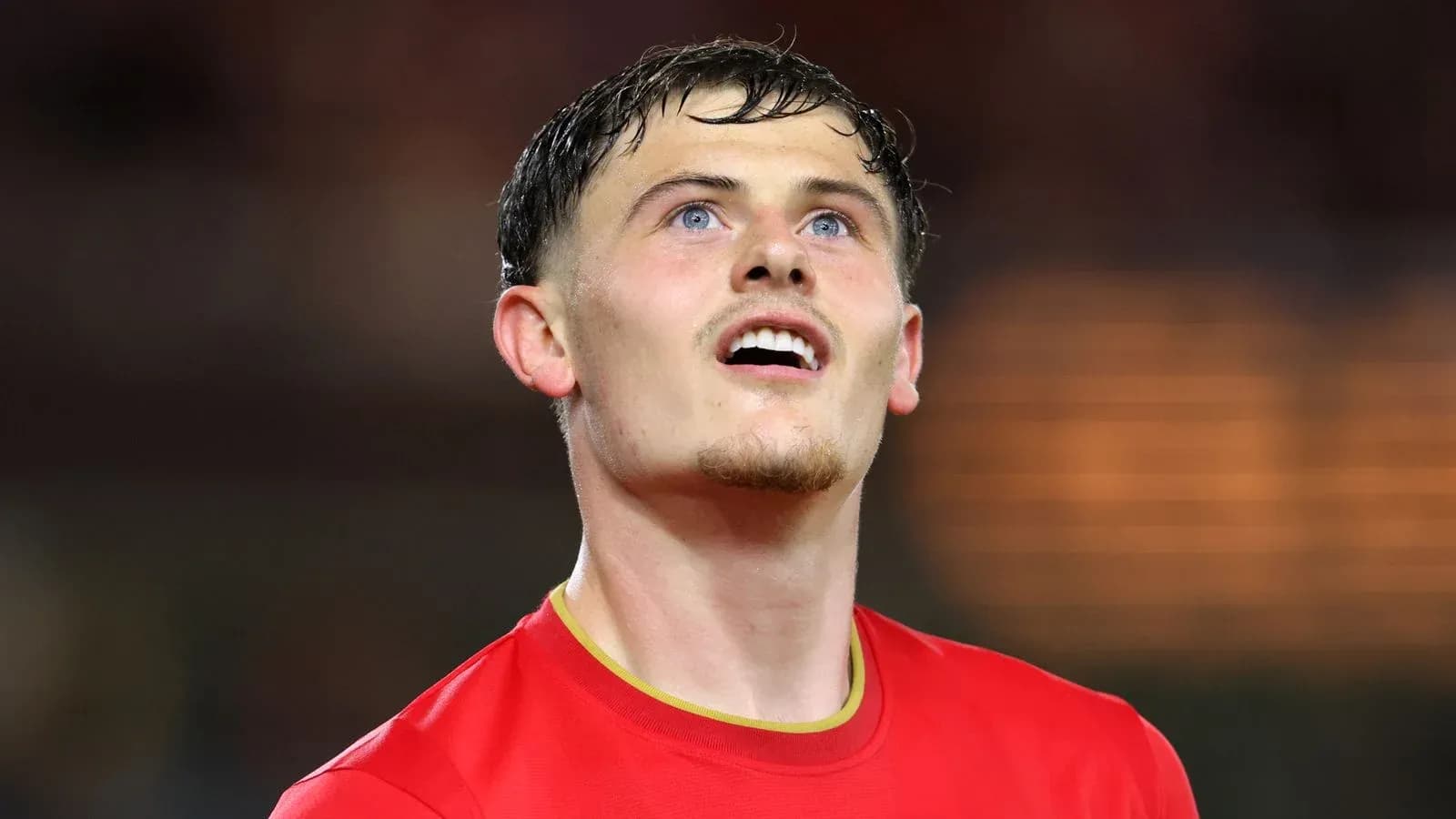 Jugador en camiseta roja mirando hacia arriba