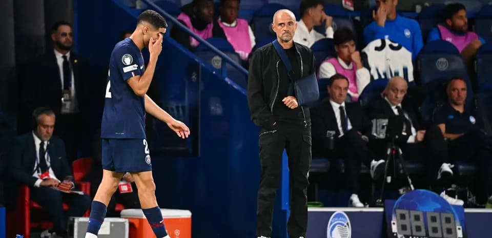 Jugador saliendo del campo mientras el entrenador observa