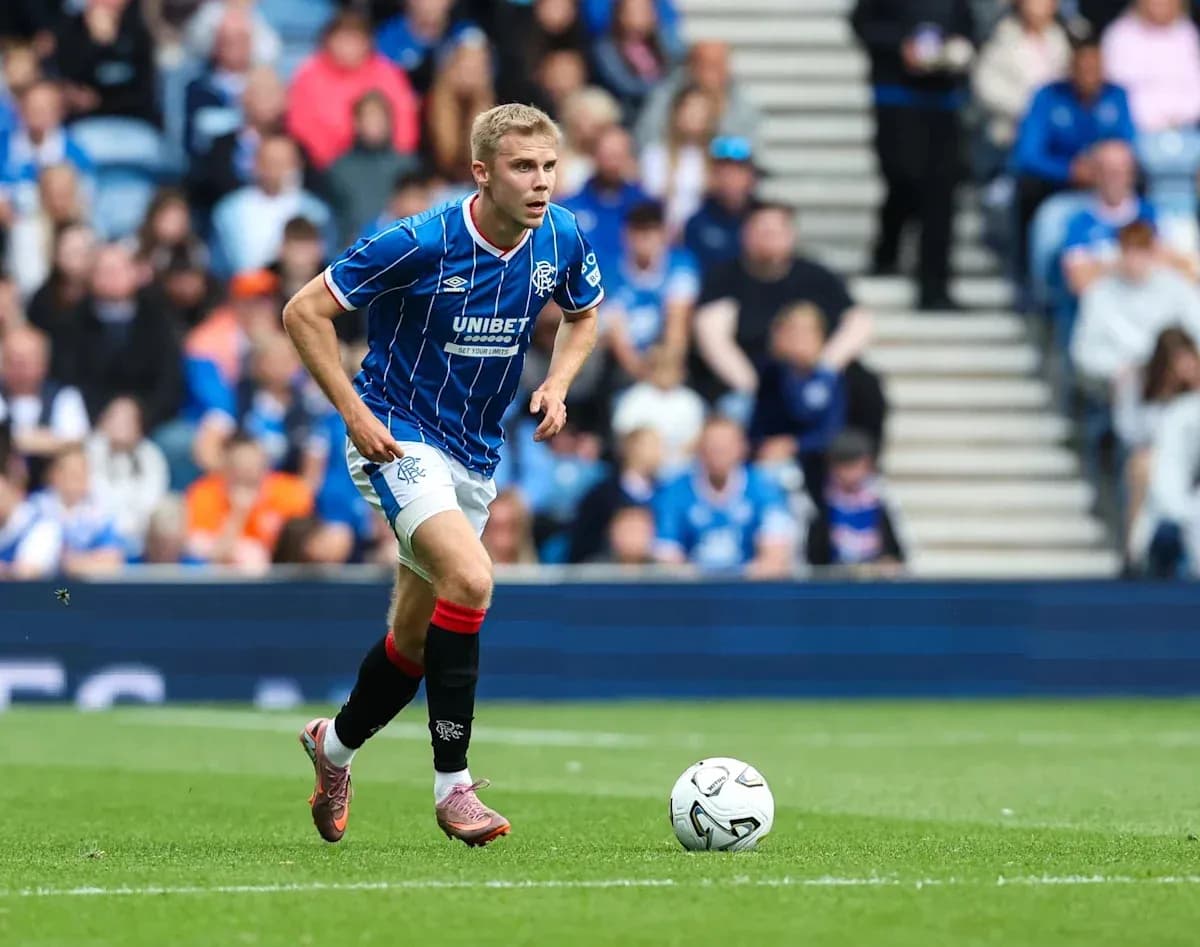 Jugador de Rangers corriendo tras el balón en el campo
