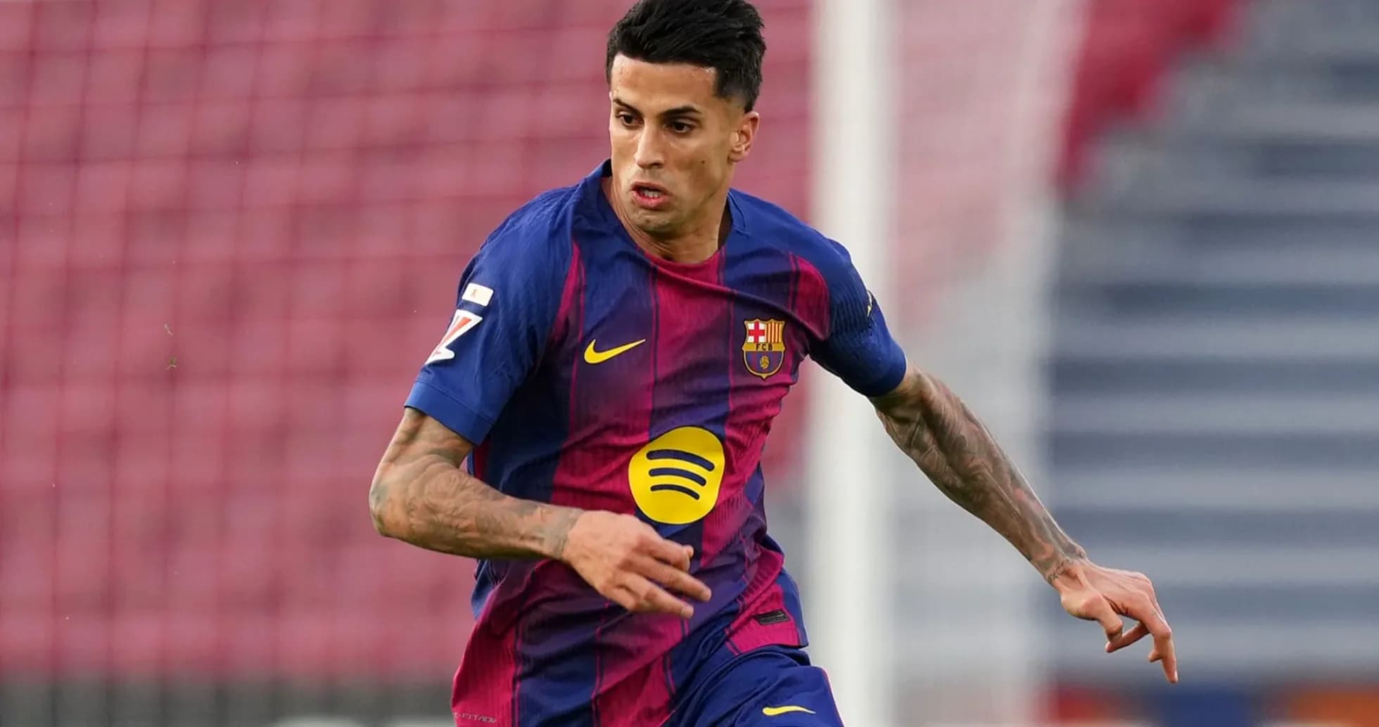 Jugador de Barcelona corriendo con el balón en el campo