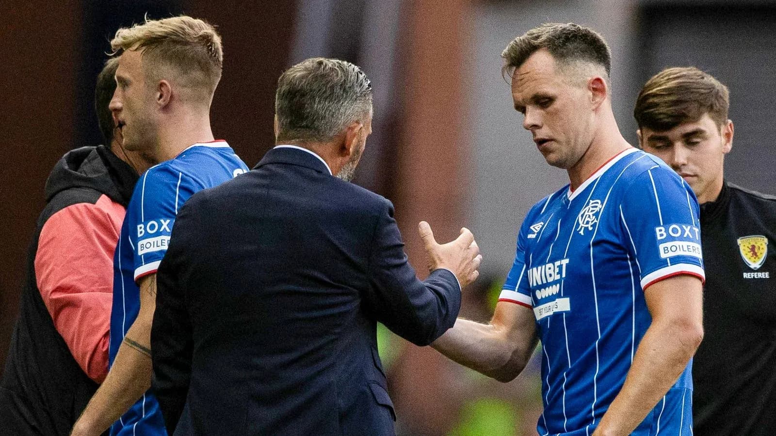 Jugadores de Rangers saludando al entrenador durante el partido