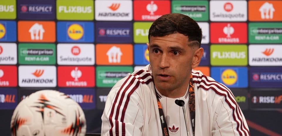 Jugador en conferencia de prensa con balón frente a él