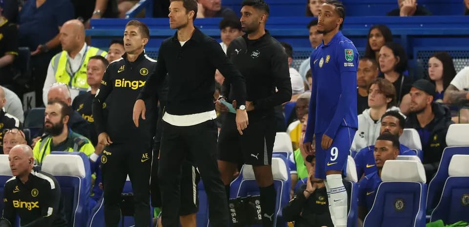 Entrenadores y jugadores en la banca durante partido