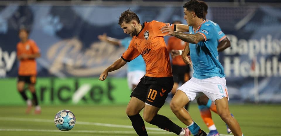 Dos jugadores compitiendo por el balón en el partido